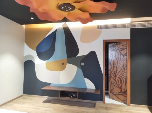 Skilled mural painter applying vibrant paints on office wall